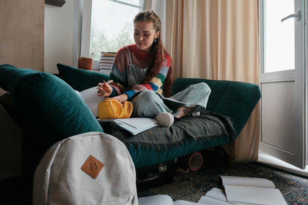 a-woman-sitting-on-a-couch-with-a-backpack