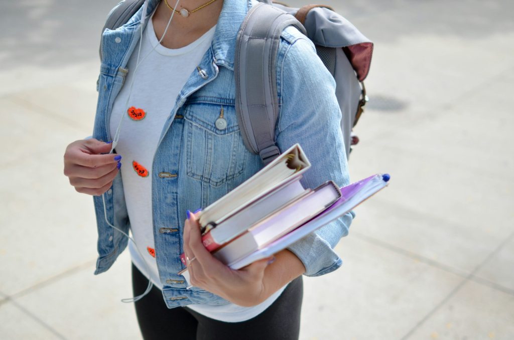 woman-wearing-blue-denim-jacket-holding-book