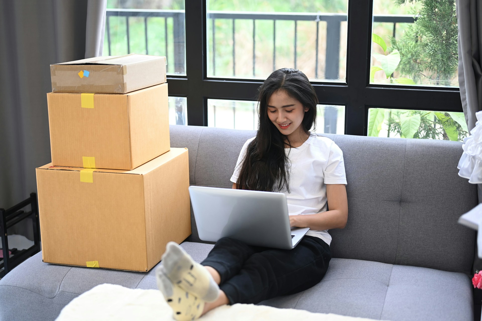 a woman sitting with moving boxes beside her